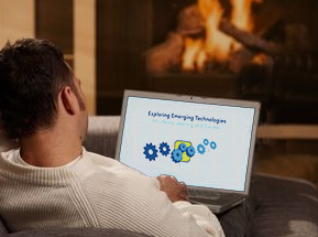 man in front of fireplace with laptop & logo
